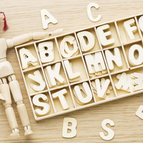 top-view-wooden-figurine-with-academic-cap-letters